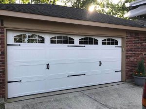 An insulated garage door in white with black hardware